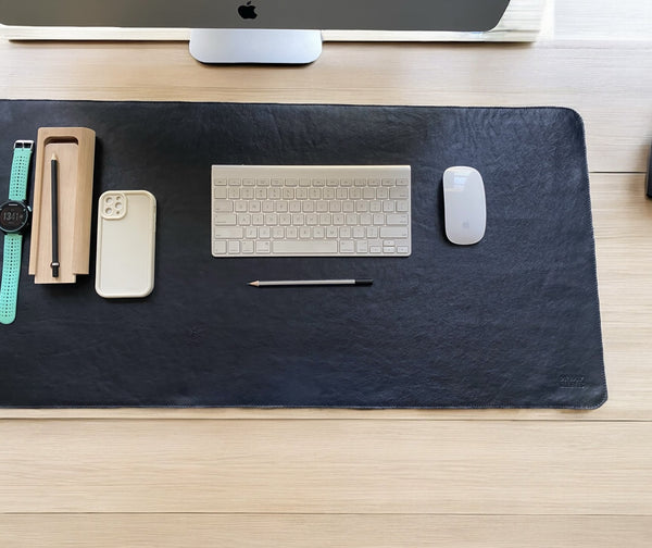 Genuine leather desk mat styled on a desk with keyboard, mouse, watch and stationery"