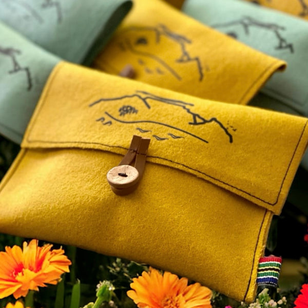 Yellow pure wool felt pouch with black Table Mountain print, wooden button and leather loop closure